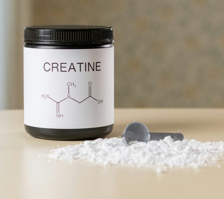 tub of creatine on a bench with scoop